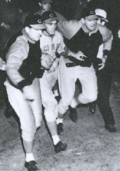 Teammates escort Johnny into the dugout.